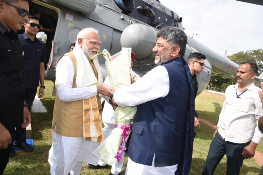 PM Modi Arrives In Mysuru, Received By Karnataka CM Shivakumar Ahead Of Viveka Smaraka Inauguration PM Modi Arrives in Mysuru, Received by Karnataka CM Shivakumar Ahead of Viveka Smaraka Inauguration Prime Minister Narendra Modi arrived in Mysuru on Saturday to inaugurate the Swami Vivekananda Cultural Youth Centre (Viveka Smaraka) at the Ramakrishna Ashrama, where he was received by Karnataka Chief Minister D.K. Shivakumar and Governor Thaawarchand Gehlot. The Chief Minister welcomed the Prime Minister at the Mysuru helipad by presenting him with a shawl and a bouquet before the two leaders proceeded to the inauguration venue. The Prime Minister is scheduled to inaugurate the Viveka Smaraka, a memorial established to commemorate Swami Vivekananda’s historic visit to Mysuru in 1892 during his journey across India, prior to his landmark address at the Parliament of the World’s Religions in Chicago in 1893. Following the inauguration, PM Modi will visit the Ramakrishna Ashrama School before departing for New Delhi from Mysuru Airport on a special aircraft. Ahead of the Prime Minister’s visit, Mysuru was placed under extensive security cover, with authorities enforcing stringent security measures and traffic restrictions across the city. More than 1,000 police personnel have been deployed under the supervision of South Zone Inspector General of Police M.B. Boralingaiah. The security arrangement includes one Superintendent of Police, one Police Commissioner, four Additional Superintendents of Police, 18 Police Inspectors, 40 Sub-Inspectors, 550 male police personnel, 350 women police personnel and 250 Home Guards. Security has been intensified around the Ramakrishna Ashrama, Oval Grounds, Mysuru Airport, and along the Prime Minister’s convoy route. Authorities have also restricted traffic on 12 major roads in the city to facilitate VVIP movement and ensure security during the visit.